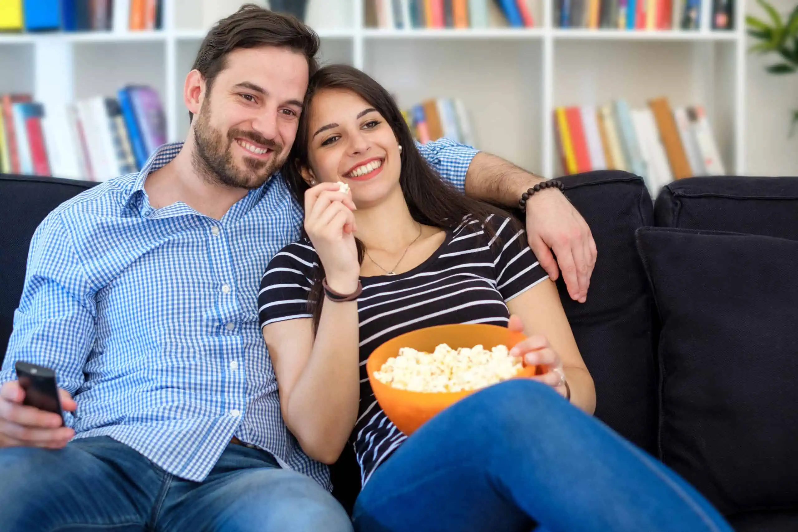 Young,Couple,Watching,Tv,At,Home,And,Having,Fun