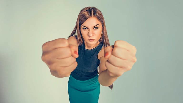 Angry young woman showing fists