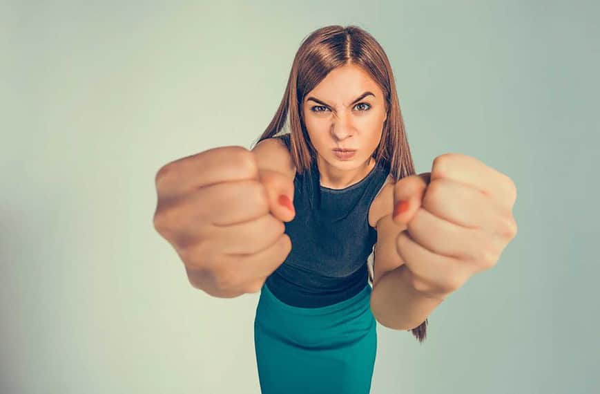 Angry young woman showing fists