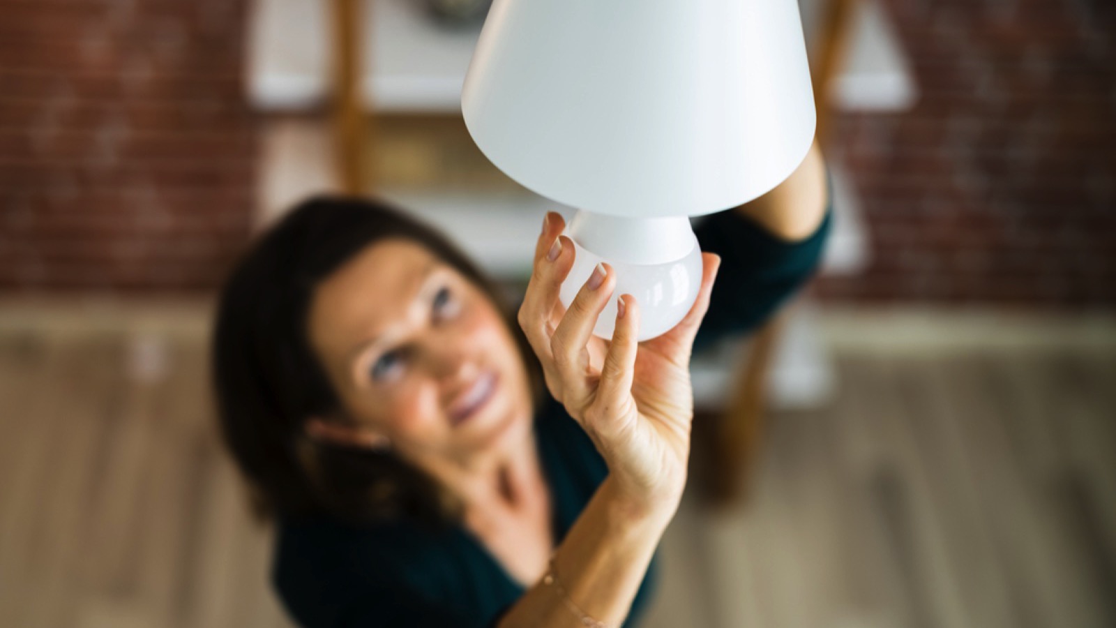 Woman fixing light bulb