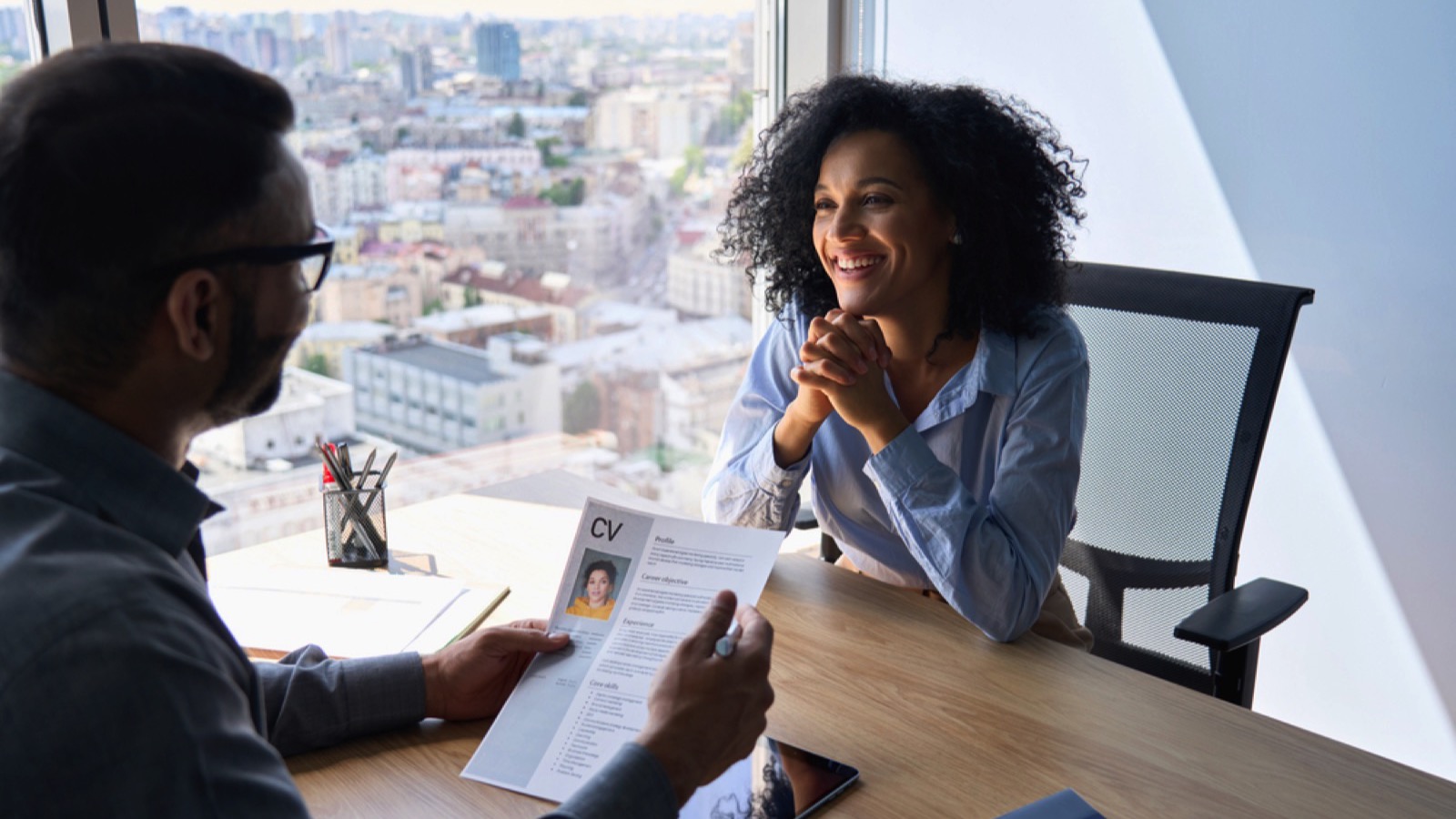 Woman giving resume to interviewer